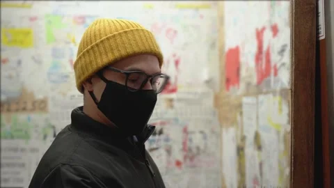 Young man in black protective face mask stands in elevator. Lift doors closing Video stock 131476985