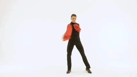 A young man in a black suit is dancing on a white background. Beautifully doing Video stock 83475373