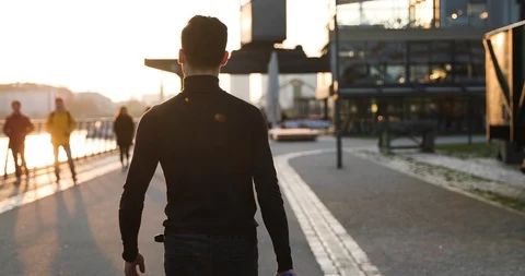 Young man in black walk with a camera on sunset in a big city. Stock Footage 126861084