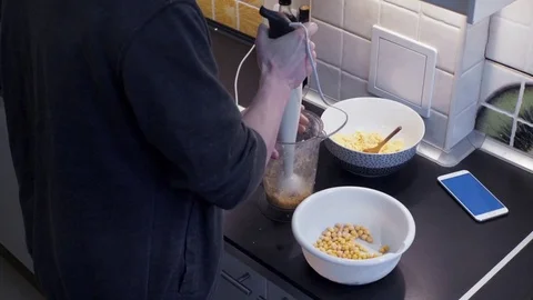 Young man with blender cooking breakfast at home kitchen and look at smartphone Stock Footage 74158183