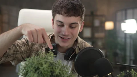 Young man blogger blogging about care of house plants at home studio 库存影片 292560053