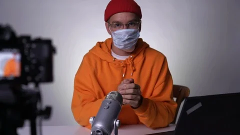 Young man blogger instructing on proper putting on a medical mask and recording Stock Footage 127388559