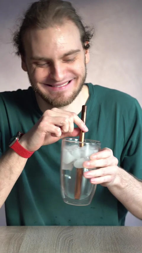 Young man blowing bubbles in ice water and laughing Stock Footage 229650984