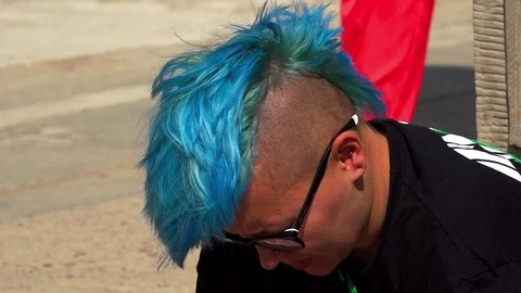 A young man with a blue mohawk on his head. 4K. Stock Footage 72112495