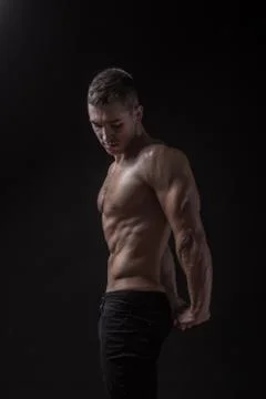 Young man bodybuilder posing side view. Stock Photos