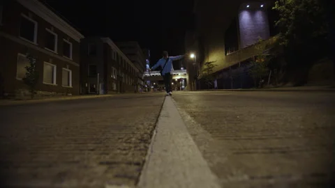 Young man with a bottle of alcohol walking on a street line trying to keep his Stock Footage 344294759