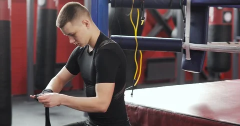 Young man boxer wrapping hands bandage before fighting or training in gym. Stock Footage 126822007