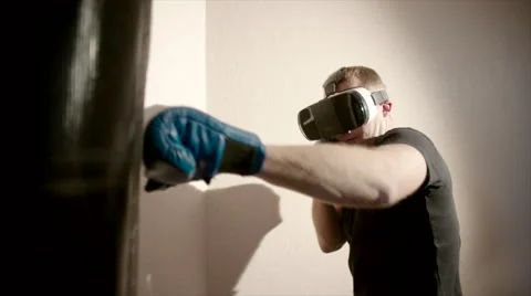 Young man boxes in the gym using VR glasses and punching bag Stock Footage 62728857