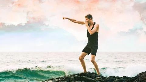 Young man boxing against the backdrop of the sea Stock Photos