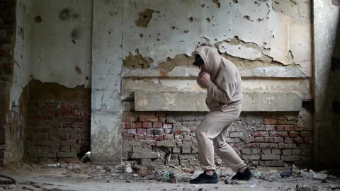A young man boxing in a destroyed building, a man performing boxing exercises. Vídeos de archivo 166329411