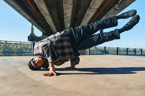 Young man break dancer dancing on urban background performing acrobatic stunts Stock-Fotos