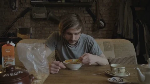 Young man at the breakfast table eating cereal Stock Footage 81295285