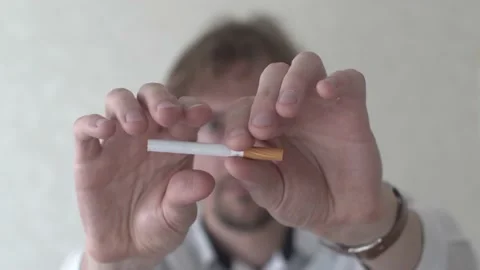 Young Man Breaking a Cigarette to Stop Smoking Stock Footage 154659293
