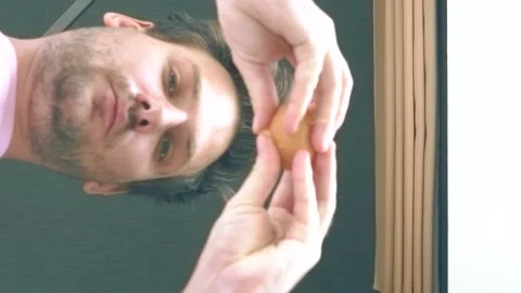 Young man breaks an egg close-up in the kitchen Stock Footage 136580546