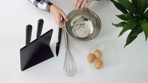 A young man breaks eggs. Closeup of chef breaking eggs into bowl Stock Footage 102554702