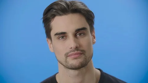 Young man breaks into a smile while looking at the camera 4K 스톡 동영상 88399348