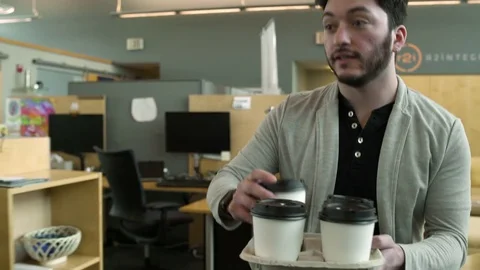 Young man bringing coffee to his co-workers 動画素材 77080198