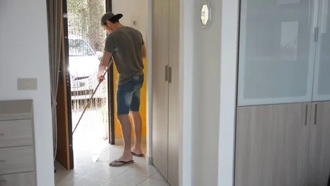 Young Man with Broom Sweeping the Floor Stock Footage 72687639