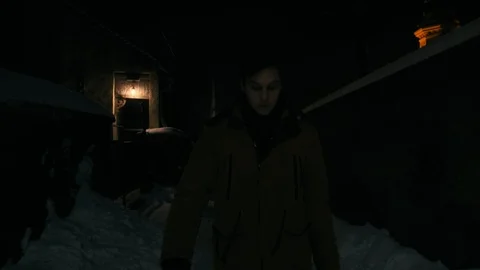 A young man in a brown jacket is walking along a dark alley. Natural street Stockbeeldmateriaal 102135848