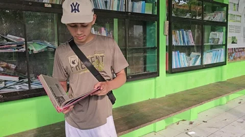 Young Man Browsing Books at Telaga Buret Nature Library Tulungagung Видео 332968272
