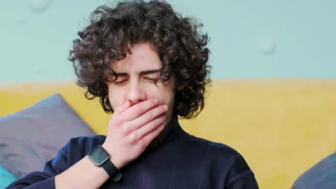 Young man is browsing at his laptop and yawning, working at the laptop. Stock Footage 154204563