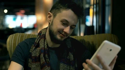 Young man browsing internet on tablet and laughing at something Stock Footage 73113781