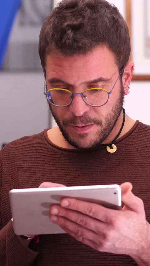 Young man browsing photos on tablet Stock Footage 295142281