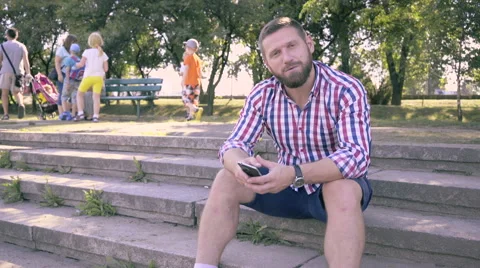 Young man browsing smartphone and telling to camera. 库存影片 67239875