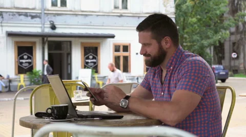 Young man browsing smartphone in cafe 库存影片 67630625