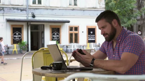 Young man browsing smartphone in cafe, slider shot right Vídeo Stock 67630716