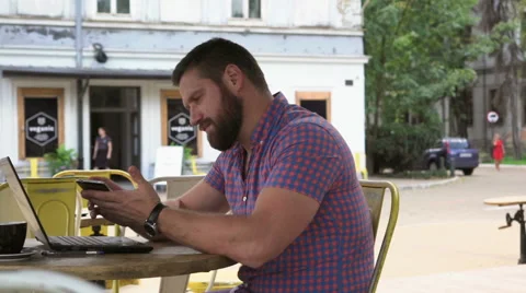 Young man browsing smartphone in cafe, slider shot left Vídeo Stock 67630879