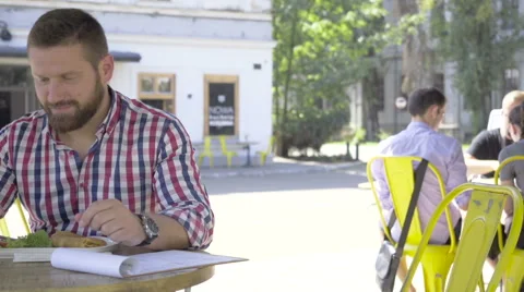 Young man browsing smartphone, during lunch, slider shot, left. Vídeo Stock 67604012