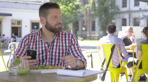 Young man browsing smartphone, during lunch, slider and pan shot. Vídeo Stock 67604042