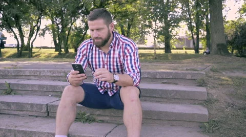 Young man browsing smartphone. Slider and pan shot. 库存影片 67240844