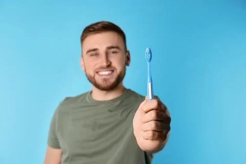 Young man with brush and toothpaste on color background, space for text. Teet Stock Photos