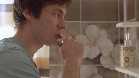 Young man brushes his teeth Stock Footage 128696407