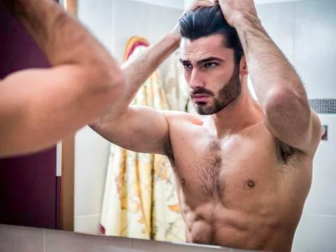 Young Man Brushing and Combing Hair in Mirror Stock Photos