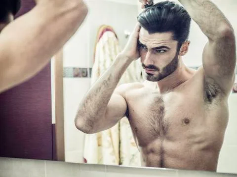 Young Man Brushing and Combing Hair in Mirror Stock Photos