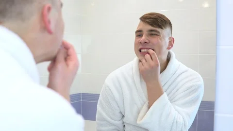 A young man is brushing his teeth. A man in a white coat looked at his teeth in Stock Footage 118720794