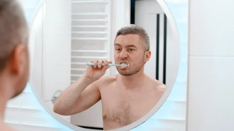 Young man brushing his teeth in bathroom Stock-Footage 254069153