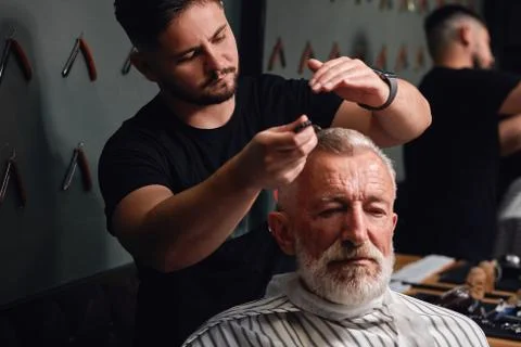 Young man brushing old man's gray hair Stock Photos