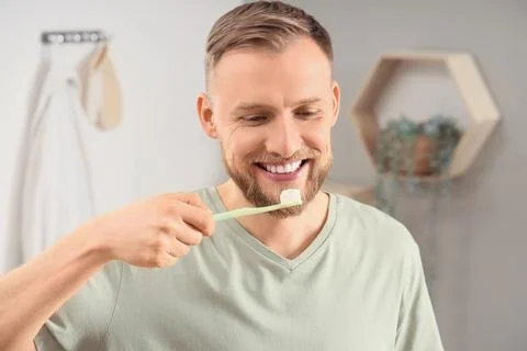 Young man brushing teeth in bathroom, closeup Stock Photos