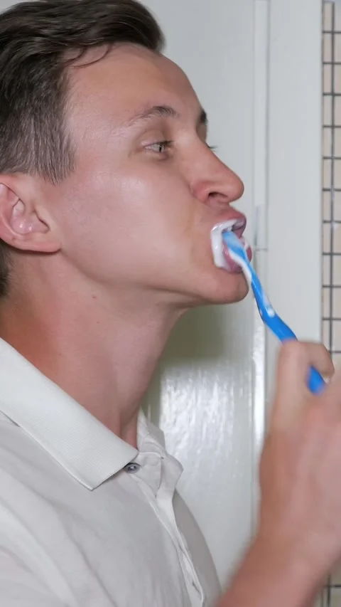 Young man brushing teeth during morning routine Stock Footage 341441702