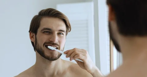 Young man brushing teeth feeling pain in bleeding gums Vídeo Stock 130027343