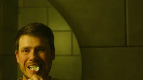 Young man brushing teeth in mirror reflection Stock-Footage 318947158