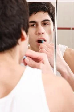 Young man brushing teeth Stock Photos