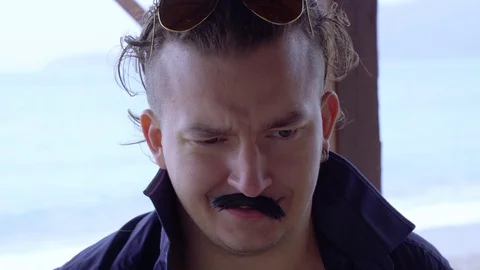 Young man with brutal expression drinks transparent white liquid. Video stock 128322363