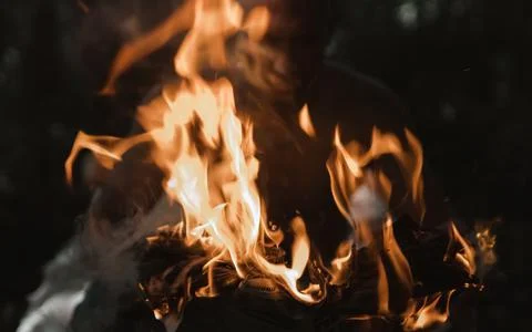 Young man with a burning match in the dark fire Stock Photos
