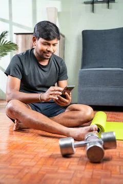 Young man busy using mobile phone during work out - Millennial checking onlin Foto stock
