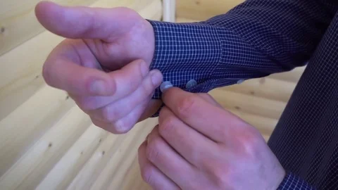Young man buttoning on the sleeves of the blue shirt Stock-Footage 75211003
